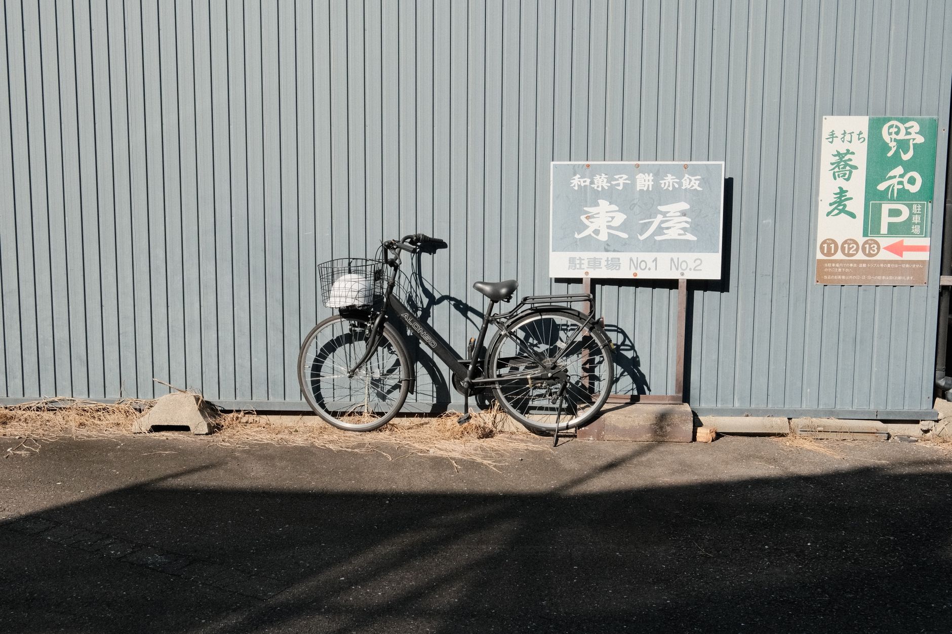Un vélo classique adossé à un mur texturé à Inuyama, Japon, capturant un moment urbain serein.